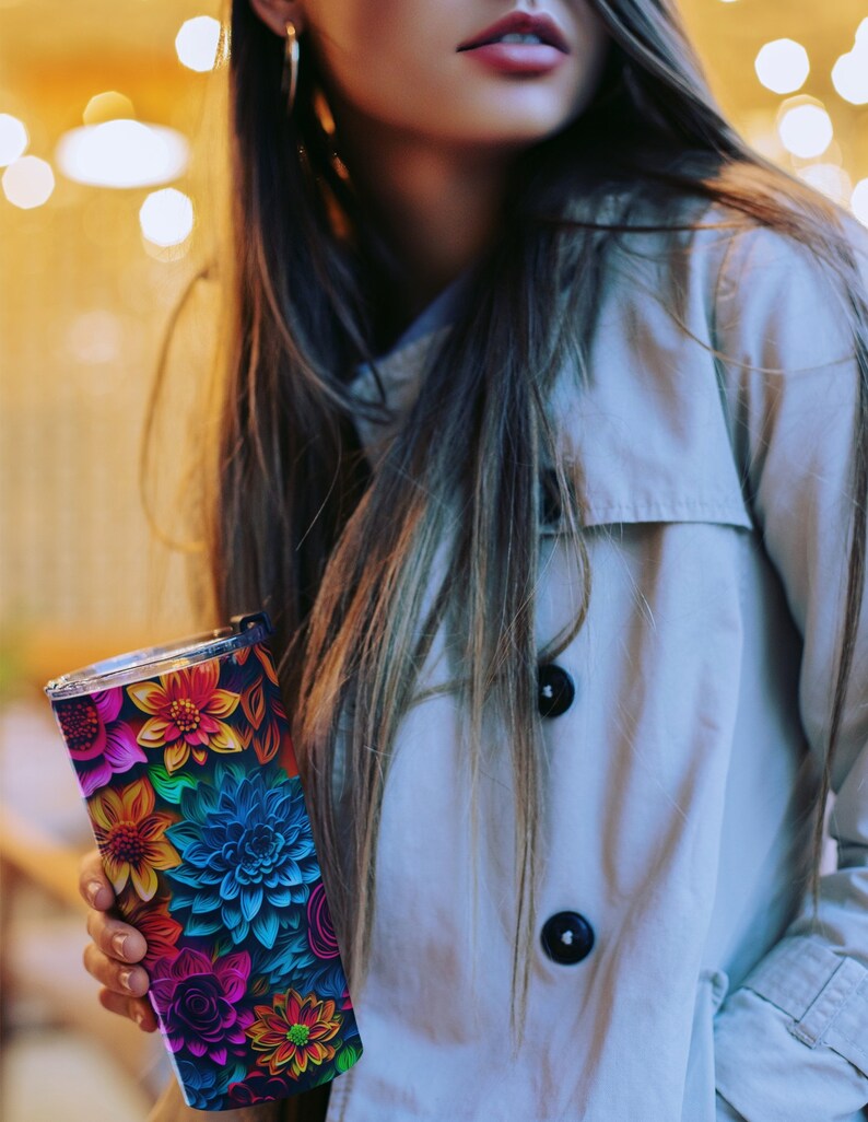 May include: A stainless steel tumbler with a colorful floral design. The flowers are in shades of blue, pink, red, yellow, and green. The tumbler has a black background.