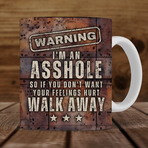 K&ouml;nnte beinhalten: Wei&szlig;e Keramiktasse mit braunem, ziegelartigem Design. Die Tasse hat eine schwarz-wei&szlig;e Grafik mit der Aufschrift "Warning I'm an Asshole So if you don't want your feelings hurt Walk Away".