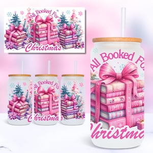 Puede incluir: Un vaso blanco con un diseño rosa y blanco que presenta una pila de libros atados con una cinta rosa y el texto "All Booked For Christmas".