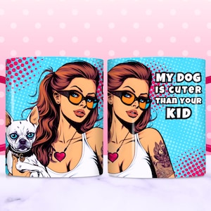 May include: A pink and blue ceramic mug with a pop art design featuring a woman with a dog. The mug has a pink handle and the text "My dog is cuter than your kid".