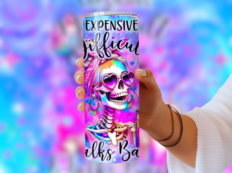 May include: A pink and purple stainless steel tumbler with a colorful skull design and the text "Expensive Difficult Looks Bad".