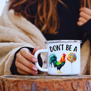 May include: White enamel mug with a black and white rooster and a colorful lollipop with the text "Don't be a" on the front.