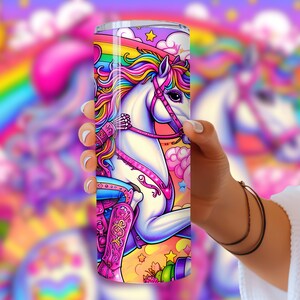 May include: A stainless steel tumbler with a colorful design featuring a unicorn wearing a pink cowboy hat and boots, riding on a rainbow against a pink and blue background with stars and clouds.