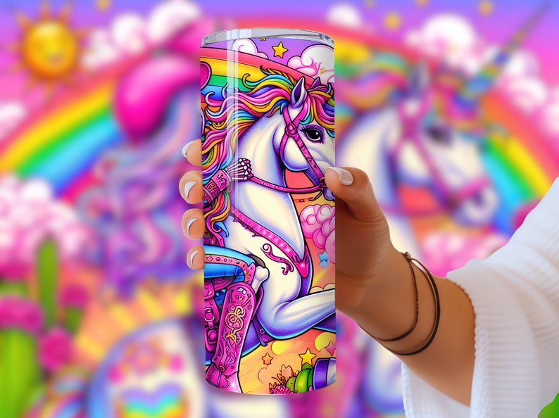 May include: A stainless steel tumbler with a colorful design featuring a unicorn wearing a pink cowboy hat and boots, riding on a rainbow against a pink and blue background with stars and clouds.