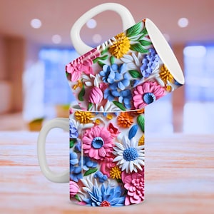 May include: Two white ceramic mugs with a floral design. The mugs feature a colorful pattern of pink, blue, white, and yellow flowers. The mugs are stacked on top of each other.