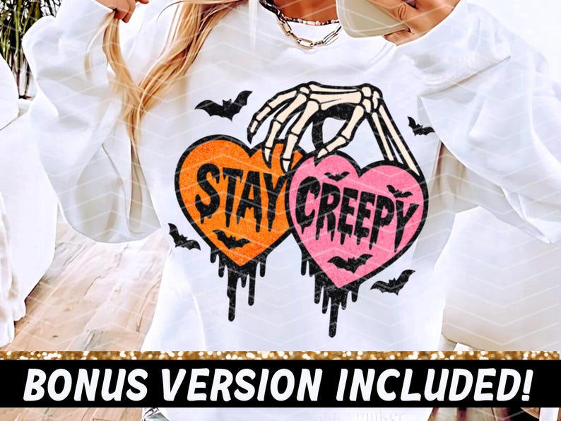 May include: White sweatshirt with a Halloween design. The design features two heart-shaped graphics with the words "STAY CREEPY" in black, held by a skeleton hand, with bat silhouettes and dripping details.