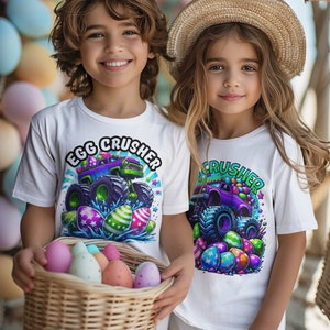 May include: Two children wearing white t-shirts with a monster truck graphic and the text "Egg Crusher". The truck is decorated with Easter eggs and the children are holding a basket of colourful Easter eggs.