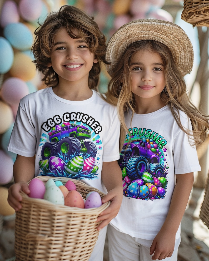 May include: Two children wearing white t-shirts with a monster truck graphic and the text "Egg Crusher". The truck is decorated with Easter eggs and the children are holding a basket of colourful Easter eggs.