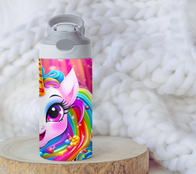 May include: A white water bottle with a gray lid and a colorful unicorn design. The unicorn has a pink body, blue mane, and rainbow tail. The background is a pink and purple galaxy with stars.