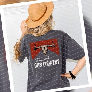 May include: A gray t-shirt with a red and white graphic of a bull skull and the text "Raised On 90's Country".