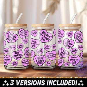 May include: Three glass tumblers with bamboo lids and white straws. Each tumbler is decorated with pink heart-shaped stickers containing various phrases. The text includes phrases like "Bitches Are People Too" and "I'm too pretty for jail."