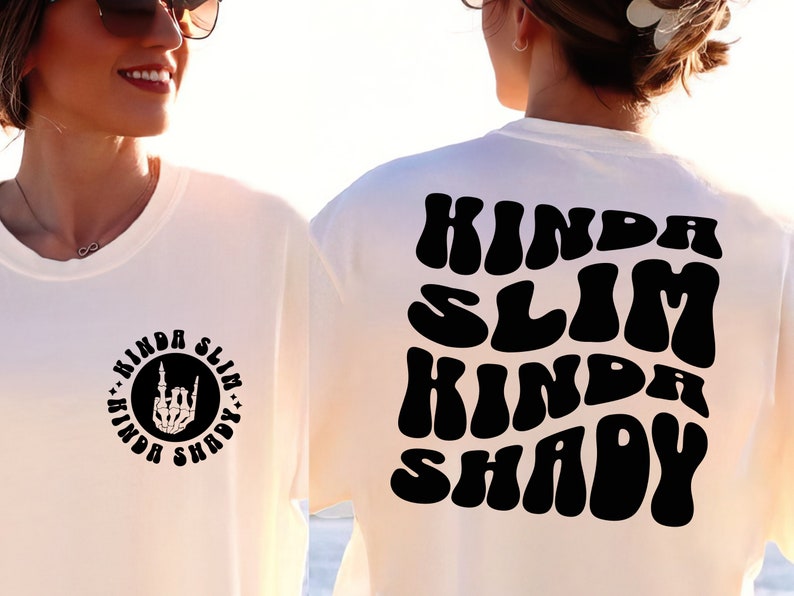 Puede incluir: Camiseta blanca con texto negro que dice "Kinda Slim Kinda Shady" en una fuente retro. El texto est&aacute; en la parte posterior de la camiseta. La parte delantera de la camiseta tiene un c&iacute;rculo negro con el mismo texto en una fuente m&aacute;s peque&ntilde;a y una mano de esqueleto haciendo el signo de rock and roll.
