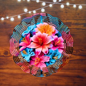 Pu&ograve; includere: Un mulino a vento in metallo colorato con un design circolare che presenta un bouquet di fiori rosa, blu e arancioni. Il mulino a vento ha un motivo ondulato a strati.