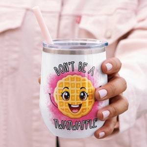 May include: White stainless steel tumbler with a pink, yellow, and brown waffle graphic. The tumbler has the text "Don't be a Twatwaffle" printed on it.
