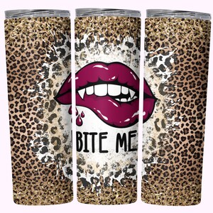 Könnte beinhalten: Ein Edelstahlbecher mit Leopardenmuster und einer zentralen Grafik von Vampirlippen mit dem Text "BITE ME". Die Lippen sind tief burgunderfarben, mit scharfen Fangzähnen und einem Blutstropfen.