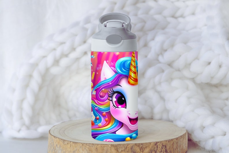May include: A white water bottle with a gray lid and a colorful unicorn design. The unicorn has a rainbow mane and tail, and is surrounded by candy and other colorful elements.