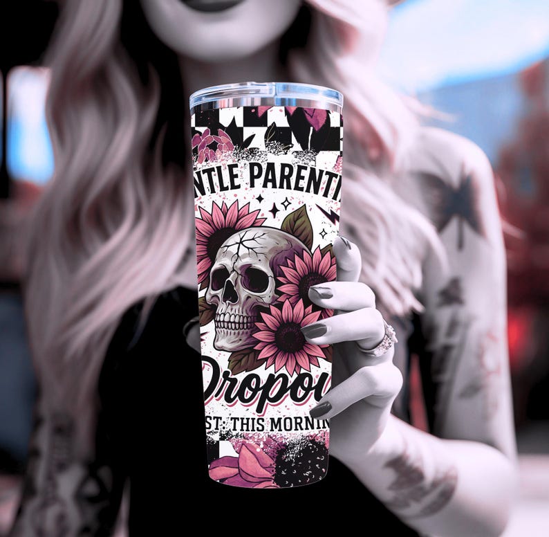 May include: A white tumbler with a pink and black design. The design features a skull with flowers and the text "Gentle Parenting Dropped Out This Morning".