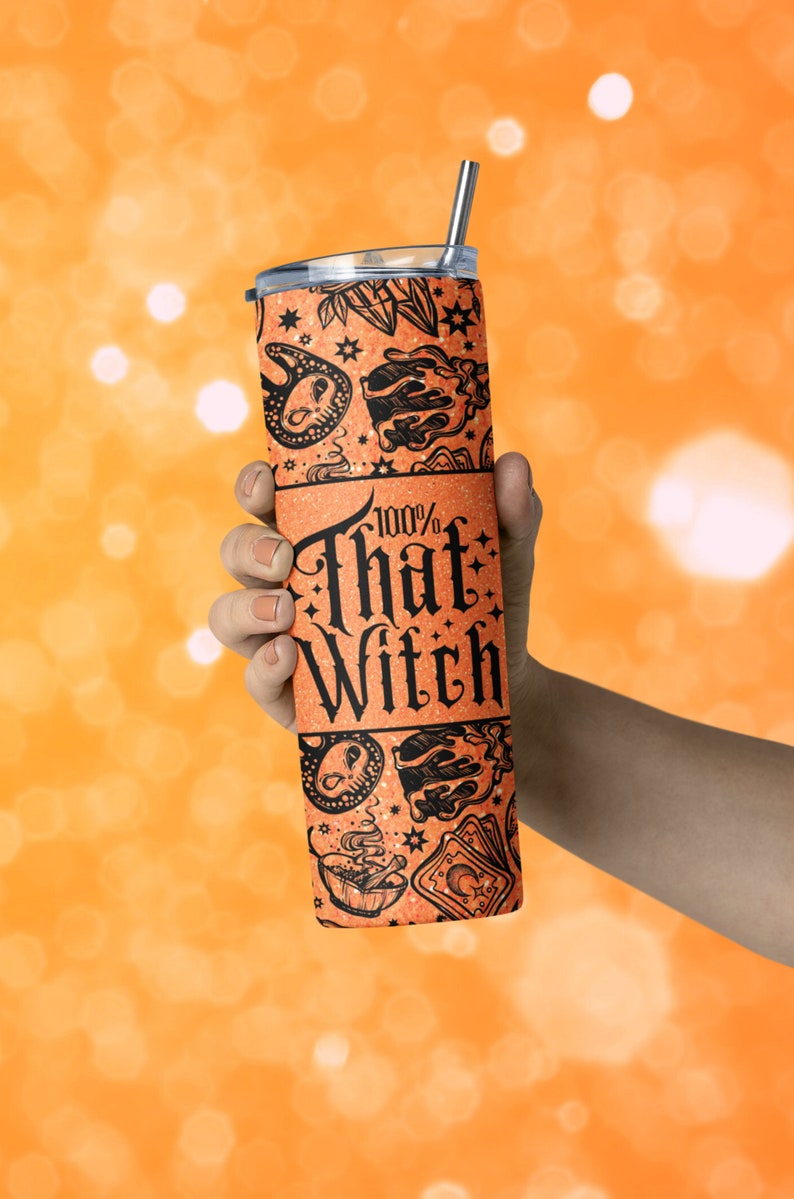以下が含まれることがあります： オレンジ色のグリッタータンブラーに、黒と白のデザインが施されています。魔女、星、その他の魔女のシンボルが描かれています。タンブラーには「100% That Witch」という文字が印刷されています。