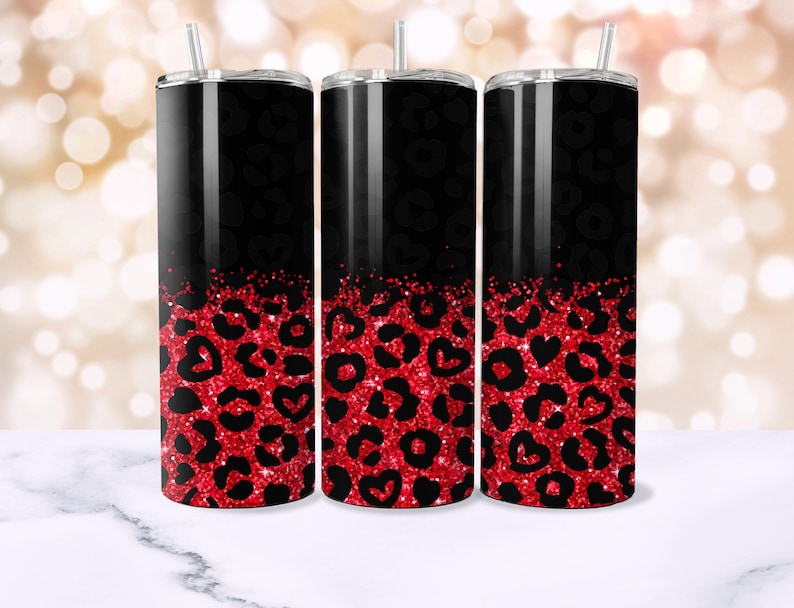 Op de afbeelding: Drie zwarte en rode roestvrijstalen bekers met een luipaardprint en rood glitterontwerp.