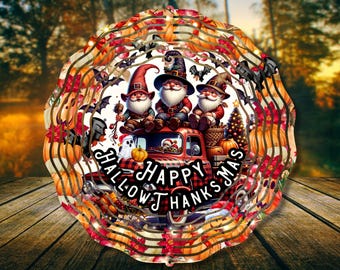 May include: A layered, circular decoration featuring a red truck with three gnomes wearing witch hats. The truck is decorated with pumpkins, bats, and the text "Happy Hallowthanksmas". The background is a blurred autumn scene.