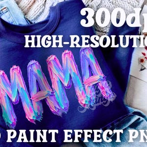 May include: A navy blue sweatshirt featuring the word "MAMA" in a vibrant 3D paint effect. The text "300dpi HIGH-RESOLUTION 3D PAINT EFFECT PNG" is also visible. The sweatshirt is displayed on a denim background.