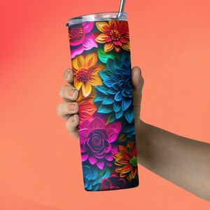 May include: A stainless steel tumbler with a colorful floral design. The flowers are in shades of pink, blue, yellow, orange, and green. The tumbler has a straw.