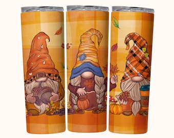 May include: Three gnomes with autumn-themed hats and outfits. The gnome on the left is holding acorns, the middle gnome is holding a pumpkin, and the gnome on the right is holding a cup of coffee. The background is a plaid pattern with falling leaves.