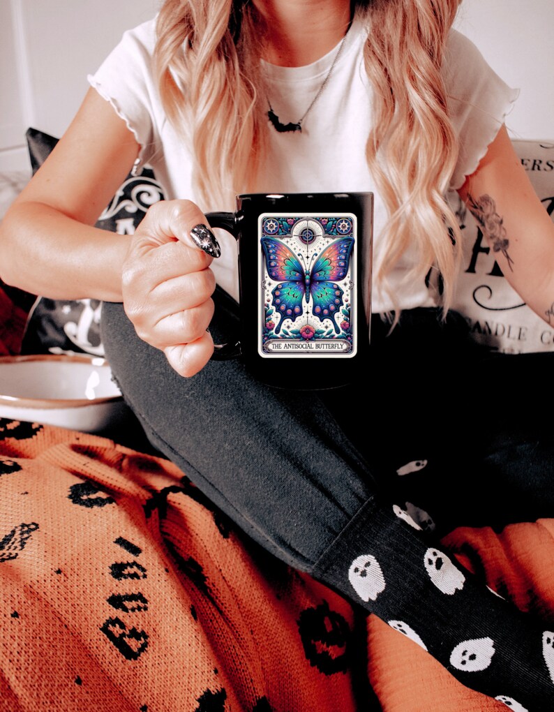 May include: Black coffee mug with a colorful butterfly illustration and the text "The Antisocial Butterfly".