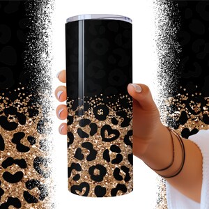 Op de afbeelding: Een zwarte en gouden glitterbeker met een luipaardprint. De beker is gemaakt van roestvrij staal en heeft een dubbelwandige constructie om dranken urenlang koud of warm te houden.