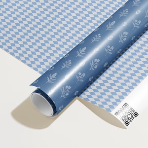 May include: A roll of blue wrapping paper with a floral design and a white and blue diamond pattern. The paper is partially unrolled, revealing the pattern. A white tube with a QR code is also visible.