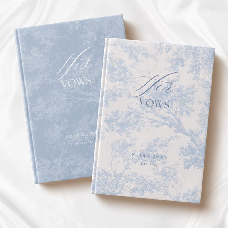 May include: Two hardcover vow books with a light blue and white toile de jouy tree pattern. The left book is light blue with white text reading His VOWS, NOAH & EMMA, and 05.16.2025. The right book is white with blue text reading Her VOWS, NOAH & EMMA, and 05.16.2025.
