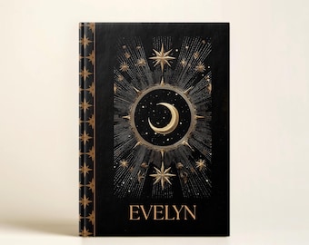以下が含まれることがあります： 黒色のノート。金色の天体デザインで、三日月、星、名前「EVELYN」が描かれています。背表紙には星の繰り返し模様があります。カバーデザインは、詳細で芸術的なスタイルで中央に配置されています。
