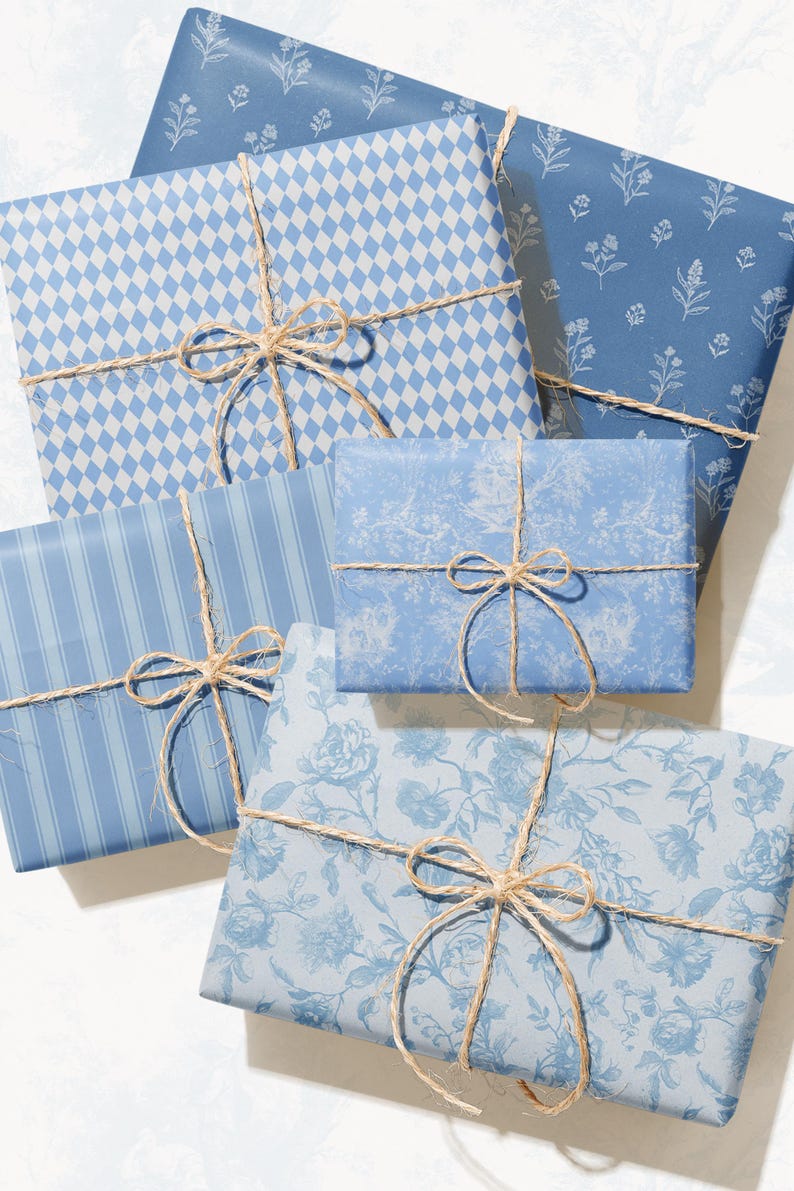 May include: An assortment of wrapped gifts in various shades of blue, tied with twine bows. The wrapping paper features patterns like diamonds, stripes, and floral designs. The gifts are arranged on a white surface.