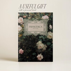 K&ouml;nnte beinhalten: Ein gr&uuml;nes Notizbuch mit floralem Muster in Wei&szlig;, mit personalisiertem Namen und dem Text "Francesca Est 2023" in einem dekorativen Rahmen.