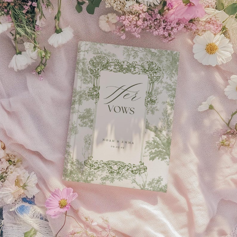 May include: A white book with a green floral design and the text "Her Vows" in cursive. The book has the names "Noah & Emma" and the date "02.26.21" printed on the front.