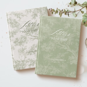 May include: Two green and white patterned hardcover journals with the text "Letters to My Baby" on the front. The journal on the left has the name "Amelia Rose" and the date "03.16.2023" printed on the front. The journal on the right has the name "James Alexander" and the date "03.16.2023" printed on the front.