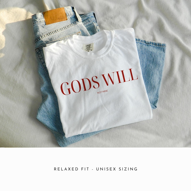 May include: White t-shirt with the text "GODS WILL NOT MINE" printed in red.