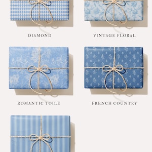 May include: Five gift boxes wrapped in blue patterned paper, tied with twine bows. Patterns include diamond, floral, toile, French country, and stripes. Text labels below each box identify the patterns.