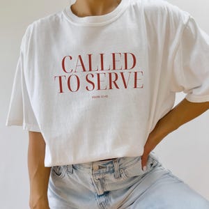 May include: White t-shirt with the text "CALLED TO SERVE" in red lettering and "MARK 10:45" in smaller red lettering below.