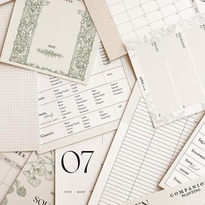 K&ouml;nnte beinhalten: Ein druckbarer Gartenplaner mit gr&uuml;nem floralem Rand und dem Text "GARDEN PLANNER" und "Don't be afraid to get dirty!" Der Planer enth&auml;lt einen Kalender, eine Liste von Gem&uuml;se und einen Bereich f&uuml;r Notizen.
