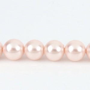 May include: A strand of pale pink pearl beads.