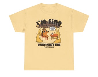 May include: A yellow t-shirt with a cartoon dog sitting in a chair with a cup of coffee. The dog is surrounded by flames and a speech bubble above the dog says "I'M FINE" and "THIS IS FINE EVERYTHING IS CURRENTLY ON FIRE". The text below the dog says "EVERYTHING'S FINE" and "THIS IS FINE".