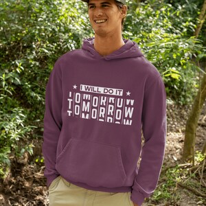 K&ouml;nnte beinhalten: Ein maroonfarbener Hoodie mit einer wei&szlig;en Grafik, auf der "Ich werde es morgen tun" steht, wobei das Wort "morgen" in einer durcheinandergebrachten Reihenfolge geschrieben ist.