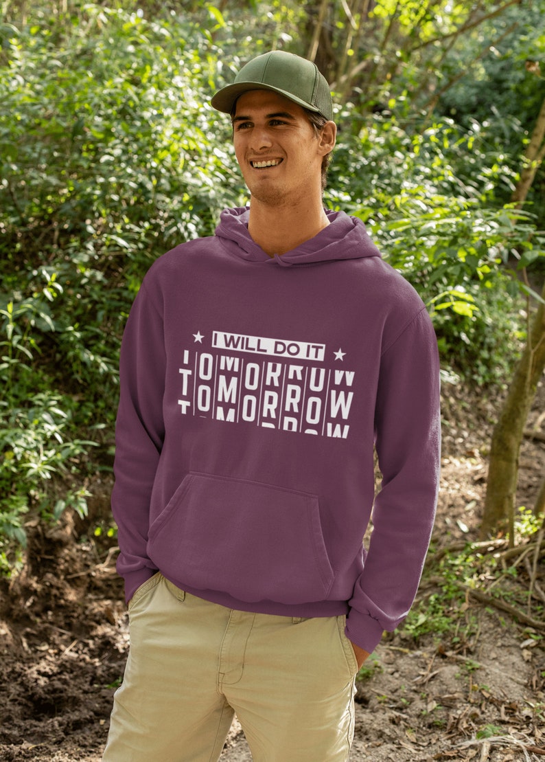K&ouml;nnte beinhalten: Ein maroonfarbener Hoodie mit einer wei&szlig;en Grafik, auf der "Ich werde es morgen tun" steht, wobei das Wort "morgen" in einer durcheinandergebrachten Reihenfolge geschrieben ist.