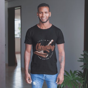 May include: A black t-shirt with a brown graphic of a cleaning tool and the text "This is my cleaning the house shirt".