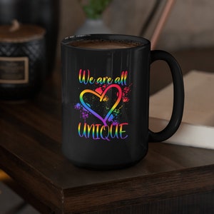 May include: Black coffee mug with a rainbow heart and the text "We are all unique".
