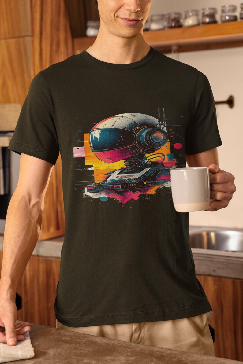May include: A dark green t-shirt with a graphic print of a robot with a helmet and a camera. The robot is surrounded by colorful geometric shapes and splatters of paint.