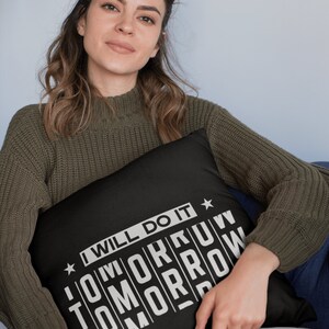 K&ouml;nnte beinhalten: Schwarzes Kissen mit wei&szlig;em Text, der "I will do it tomorrow" lautet. Der Text ist in Blockschrift und die Buchstaben sind &uuml;bereinander gestapelt.