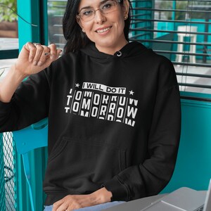 K&ouml;nnte beinhalten: Ein schwarzer Hoodie mit einem wei&szlig;en Aufdruck, der "I will do it tomorrow tomorrow tomorrow" lautet.