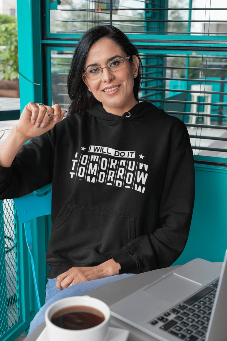 K&ouml;nnte beinhalten: Ein schwarzer Hoodie mit einem wei&szlig;en Aufdruck, der "I will do it tomorrow tomorrow tomorrow" lautet.